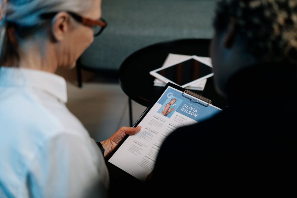 a woman looking at a resume, representing ways to ass resume to your linkedin account