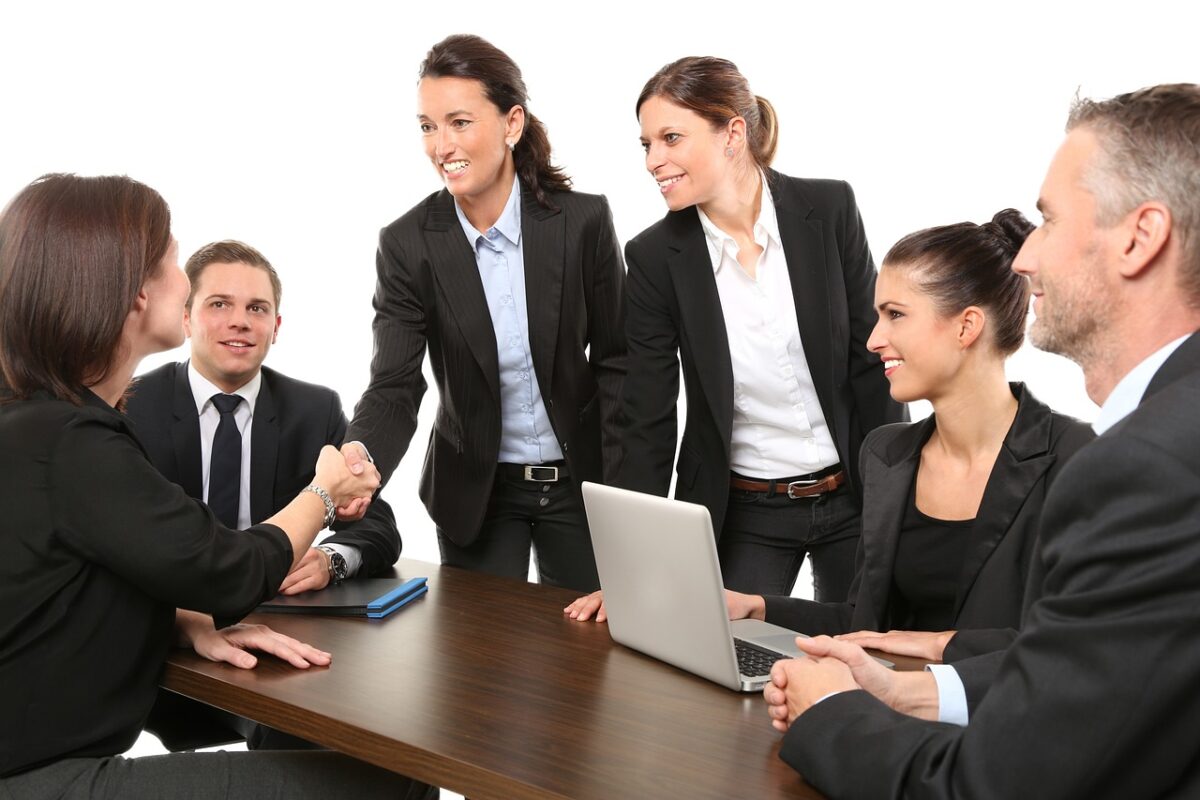 Several corporate figures shaking hands after a meeting.